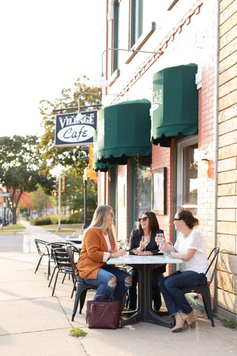 Three friends eating outside Little Village Café in Downtown Baraboo