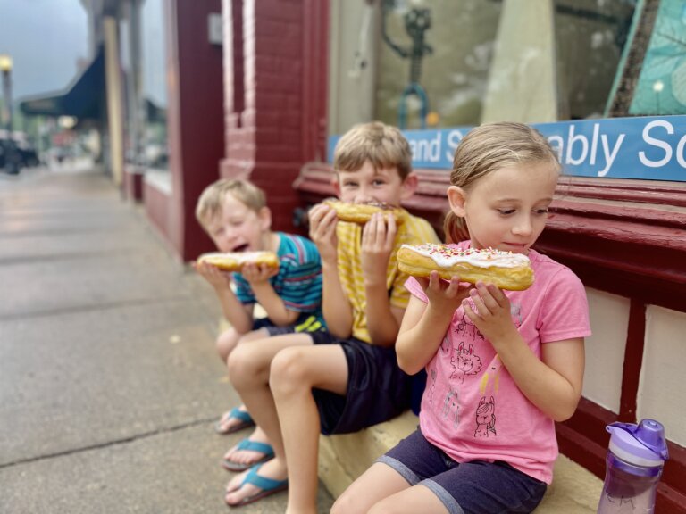 Three kids eating donuts