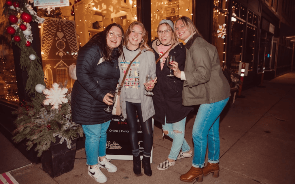 Winter Wine Walk in Baraboo. 4 ladies drinking wine and smiling outside a shop