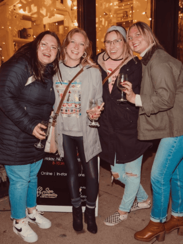 Winter Wine Walk in Baraboo. 4 ladies drinking wine and smiling outside a shop