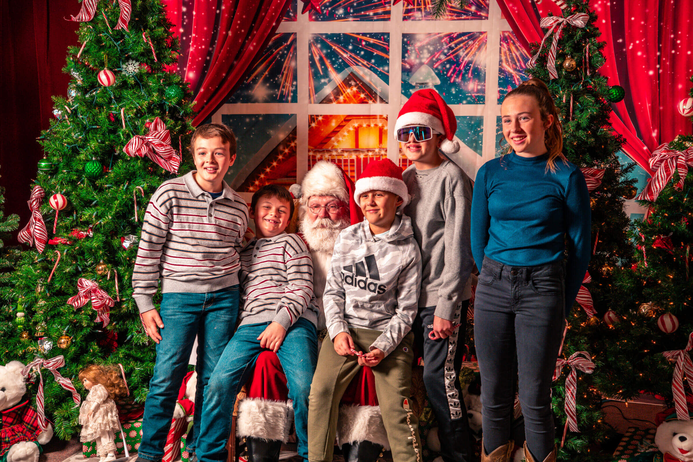 Five children meeting Santa, with festive holiday decor around them