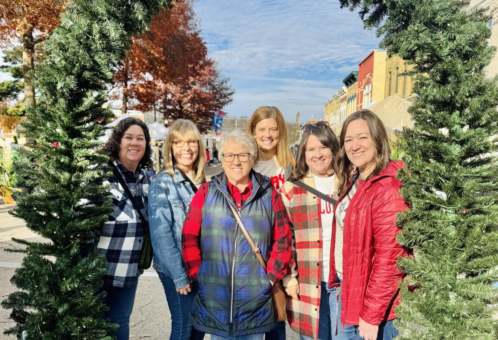 Six women shopping in Downtown Baraboo with a Christmas garland arch