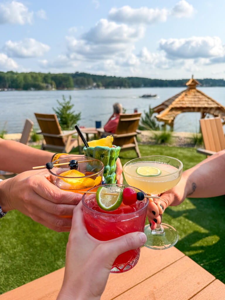 Four woman toasting their cocktails outside at Daylene's supper club, with a gorgeous lakeview.