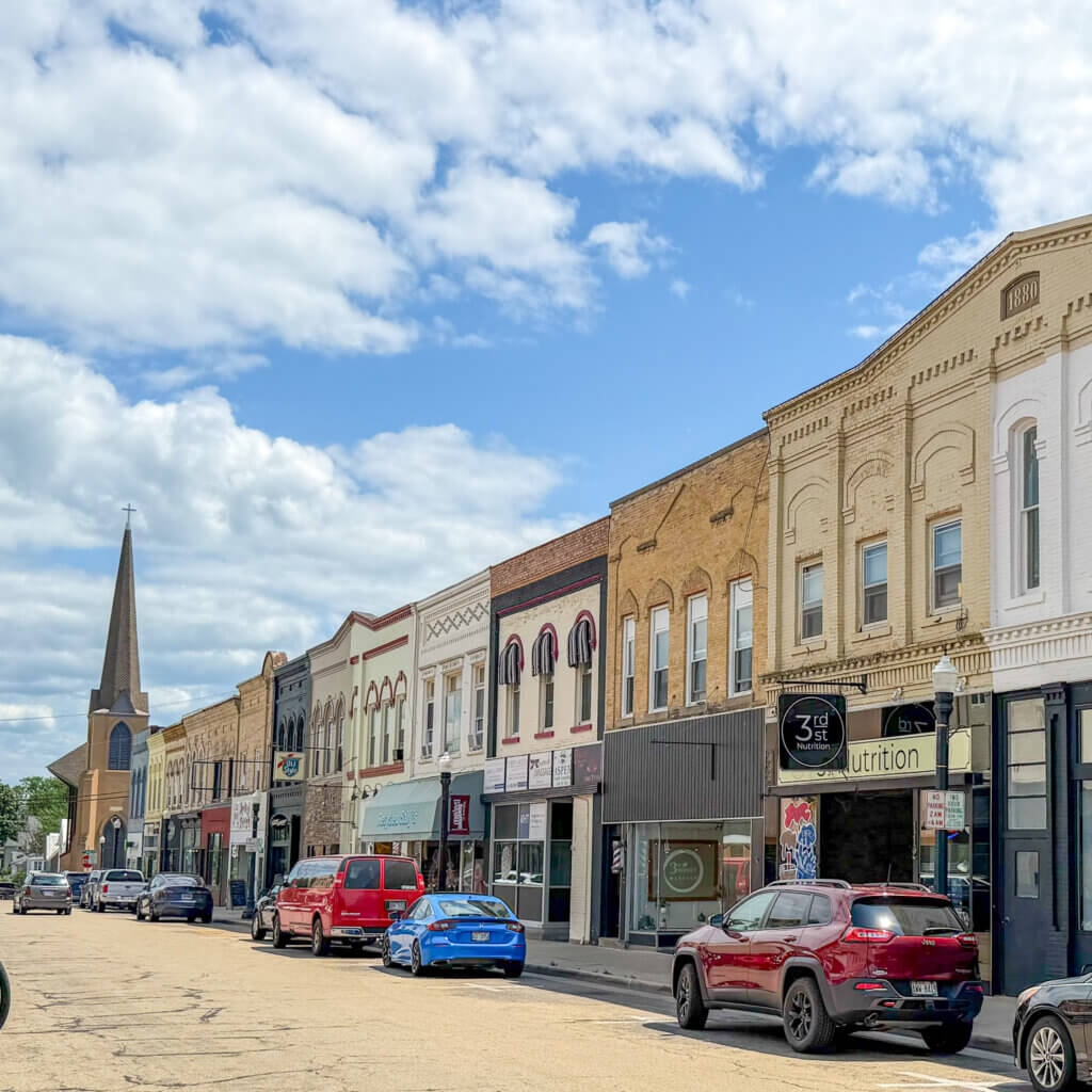 A view of a downtown Baraboo street with shops and historic architecture on a sunny day