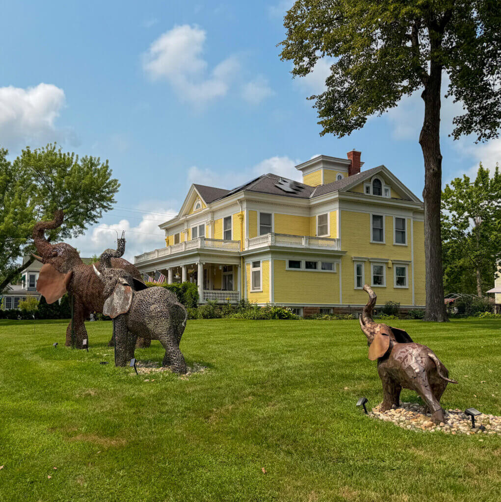 Ringling Mansion in Baraboo, WI where the Ringling Brothers grew up. Shows a large yellow mansion and metal elephants