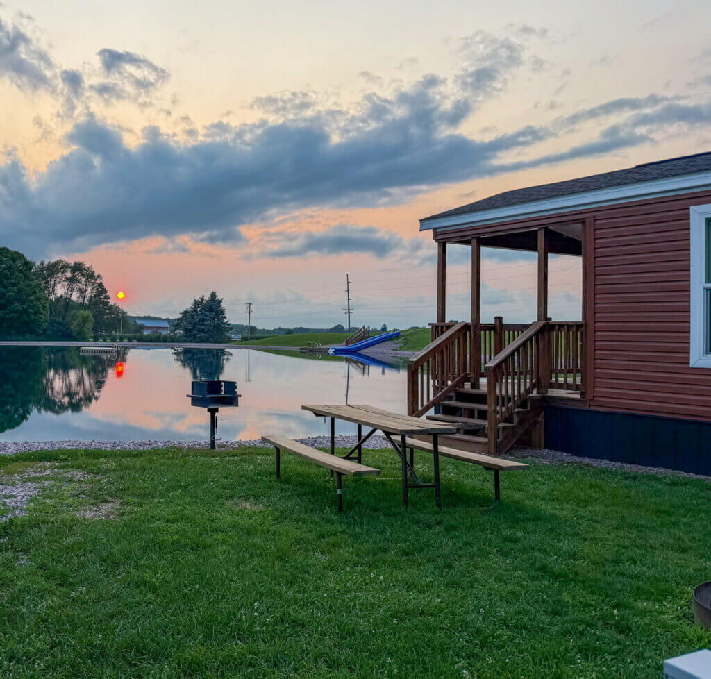 Sunset at Skillet Creek Campground showing a pond for swimming and a cabin for rent