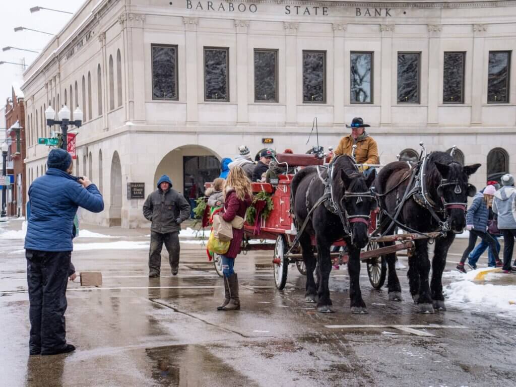 A horse-drawn carriage waits outside the historic Baraboo State Bank in the snow